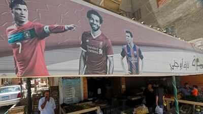 A banner with pictures of the English football club Liverpool player Mohamed Salah, Barcelona's Lionel Messi and Cristiano Ronaldo of the Italian club Juventus, is seen above a cafe that has been transformed into a vegetable shop in Cairo, Egypt. Reuters