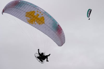 Paragliders take part in a display in Damascus to mark the first anniversary of the downfall of former president Bashar Al Assad. AP