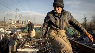 Chinese labourers load scrap metal onto a truck to be recycled in the Dong Xiao Kou village. Kevin Frayer / Getty Images