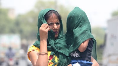 A woman and child in New Delhi try to cover up to avoid the sun during the heatwave last year. EPA