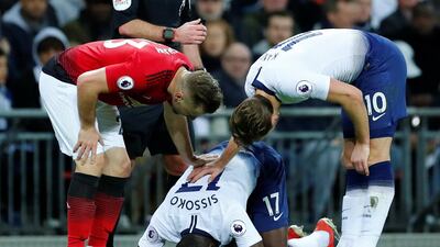 Tottenham's Moussa Sissoko reacts after going down as Kane and Manchester United's Luke Shaw stand over him. Reuters
