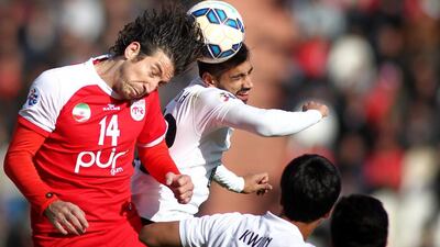 Tractor Sazi midfielder Andranik Teymourian, left, fights for the ball with Majid Hassan of Al Ahli during their Asian Champions League match at Yadegar Emam Stadium in the northwestern Iranian city of Tabriz on March 4, 2015. Mehdi Zare / AFP