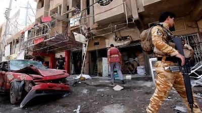 An Iraqi soldier inspects the scene of a car bomb attack in the Sha'ab neighborhood of Baghdad.