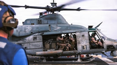 U.S. Marines with the 31st Marine Expeditionary Unit load onto a UH-1Y Venom aboard USS Tripoli (LHA 7) to conduct aerial sniper and close air support training while transiting regional waters. Photo: Centcom / X