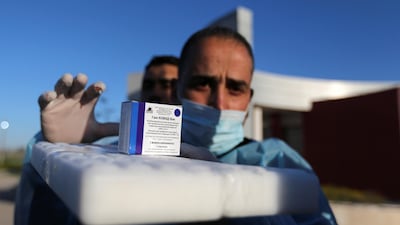 A Palestinian health worker displays a box of Russia’s Sputnik V vaccine donated by the UAE. Reuters