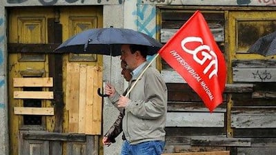 Demonstrators at a workers' protest walk past a boarded up building in downtown Porto, Portugal. (AP Photo/Paulo Duarte)