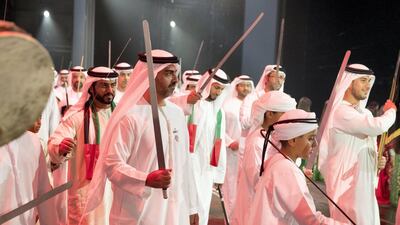 Sheikh Zayed bin Mohammed bin Hamad bin Tahnoon Al Nahyan, right, and Sheikh Hamed bin Zayed Al Nahyan, Chairman of the Crown Prince Court of Abu Dhabi and Abu Dhabi Executive Council Member, second right, dance during the 46th UAE National Day celebrations at Mushrif Palace. They are seen with Sheikh Abdullah bin Mohammed bin Khaled Al Nahyan, back left. Hamad Al Kaabi / Crown Prince Court - Abu Dhabi