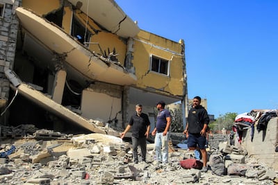 People inspect the damage from an an overnight Israeli attack on Lebanon's southern village of Ain Qana. AFP