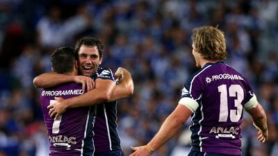 Cameron Smith, Cooper Cronk and Todd Lowrie of the Storm celebrate at full-time after winning the 2012 NRL Grand Final match between the Melbourne Storm and the Canterbury Bulldogs. Cameron Spencer / Getty Images