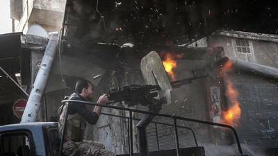 Fighting to the bitter end: a rebel fighter fires a gun towards a building where Syrian troops loyal to President Bashar Al Assad are hiding in the Jedida district of Aleppo. Narciso Contreras / AP Photo