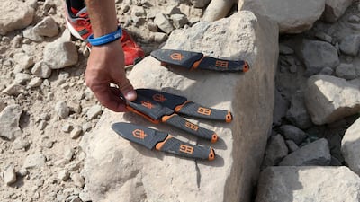 Instructor David Sculthorpe gives knives to the participants for the Bear Grylls Survival Academy adult survival course. Pawan Singh / The National
