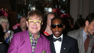 Elton John, in a purple suit, green checked shirt and metallic green shoes, and Tinie Tempah on the front row for the Richard James spring/summer 2013 show in London on June 17, 2012. Getty Images