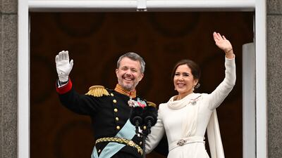 King Frederik X and Queen Mary of Denmark wave from the balcony of Christiansborg Palace in Copenhagen on Sunday. AFP