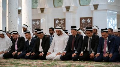 Sheikh Mohamed bin Zayed, centre right, and Sultan Abdullah, centre left, attend Friday prayers at Sheikh Zayed Grand Mosque.