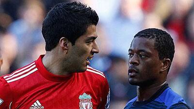 Luis Suarez, the Liverpool striker, left, stares at Patrice Evra, the Manchester United left-back, during their 1-1 draw at Anfield yesterday.