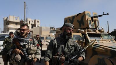 A fighter of the Syrian Democratic Forces (SDF) carries a weapon as he stands near a military vehicle in Raqqa, Syria, on October 16, 2017. Rodi Said / Reuters