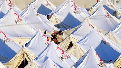 Syrian refugees walk betwen tents in the Boynuyogun Turkish Red Crescent refugee camp in the Altinozu district of Hatay, near the Syrian border yesterday. Syrian opposition activists have set up a 'National Council' to spearhead the battle to oust President Bashar Al Assad's regime.