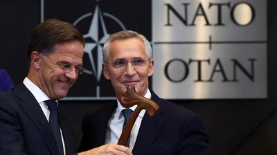 Jens Stoltenberg, left, hands over the ceremonial gavel to new Nato Secretary General Mark Rutte, at Nato headquarters in Brussels. Reuters