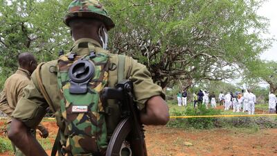 Kenyan police officers stand guard as forensic experts exhume bodies believed to be of cult members. Reuters