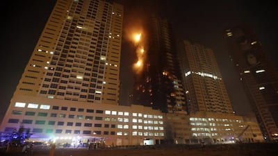 Members of the Civil Defence work to extinguish a fire at residential buildings in the Sowan area of Ajman. Ali Haider / EPA