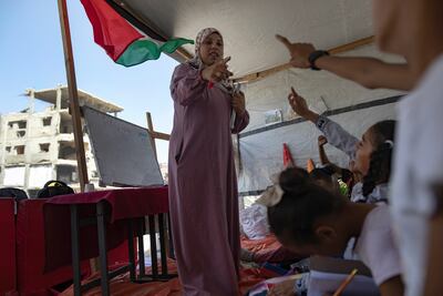 Israa Abu Mustafa teaches in a tent on the rubble of her house in Khan Younis. EPA