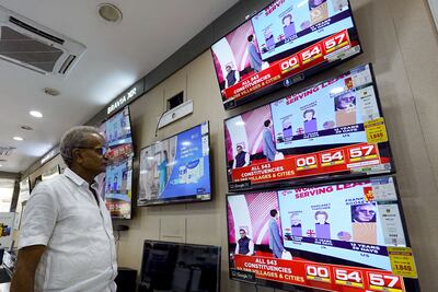 A man watching television waits for the release of exit polls published after voting concludes in India's general election. AFP