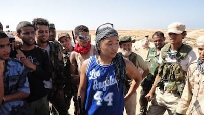 Chris Jeon, 21, a student at at University of California - Los Angeles, decided to travel to Libya to join the rebels for the last six weeks of his summer vacation. Here he is surrounded by rebels who are amassing about 130km from Colonel Muammar Qaddafi's hometown and stronghold.