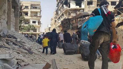 Syrians carry their belongings as they prepare to evacuate Daraya on August 26, 2016. Local Council of Daraya City via AP