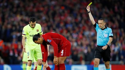 Sergio Busquets is shown a yellow card by referee Cuneyt Cakir after fouling Liverpool's Fabinho Reuters