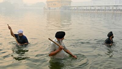 Volunteers clean the Amritsar Sarovar a day after the Sikh festival Bandi Chhor Divas, as a thick smog engulfs the Golden Temple in Amritsar. AFP