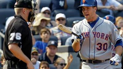 New York Mets' Josh Thole reacts near home plate umpire Mike Muchlinski after striking out against the Yankees