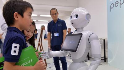 Japanese mobile communication giant Softbank's humanoid robot "Pepper" (R) chatting to children at a high-tech gadgets exhibition in Tokyo. Yoshikazu Tsuno / AFP
