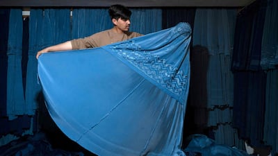An Afghan vendor displays a burqa at his shop at Mandawi market in Kabul on May 8, 2022. AFP