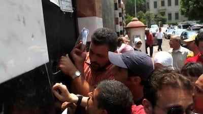Syrians queue in front of the Syrian Embassy in Cairo to pick up their passports after Egyptian president Mohammed Morsi cuts diplomatic ties with Damascus.