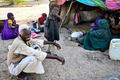 People stranded in an inundated area in Tokar in the Red Sea State following recent heavy flooding in eastern Sudan as they sit outside a tent on September 5, 2024. AFP
