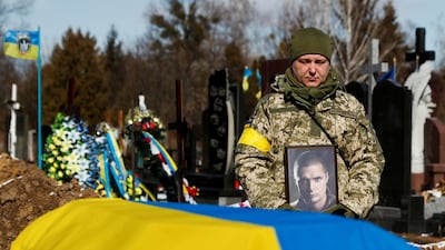 Members of the Honour Guard hold a portrait of a killed member of the Ukrainian Armed Forces during a funeral ceremony in Kyiv. Reuters