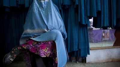 An Afghan woman waits to get in line.
