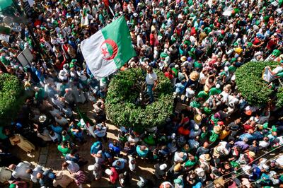 Algerian demonstrators chant slogans and march with national flags in the streets of the capital Algiers. Ryad Kramdi / AFP