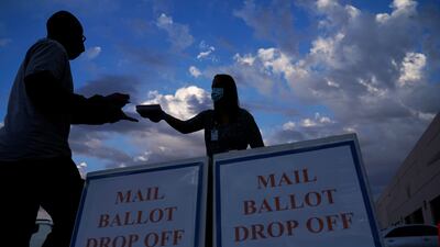 A county worker collects a mail-in ballot in a drop off area at the Clark County Election Department in Las Vegas. AP