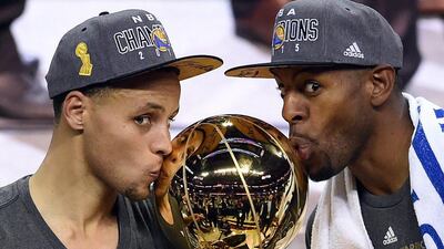 Stephen Curry #30 and Andre Iguodala #9 of the Golden State Warriors celebrate with the Larry O’Brien NBA Championship Trophy after defeating the Cleveland Cavaliers in Game Six of the 2015 NBA Finals at Quicken Loans Arena on June 16, 2015 in Cleveland, Ohio. NOTE TO USER: User expressly acknowledges and agrees that, by downloading and or using this photograph, user is consenting to the terms and conditions of Getty Images License Agreement. Jason Miller/Getty Images
