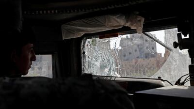 A member of the Syrian Democratic Forces drives an armoured vehicle past destroyed buildings in Raqqa, Syria on September 30, 2017. Erik De Castro / Reuters