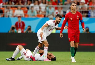 Portugal's Cristiano Ronaldo walks away as Iran's Ramin Rezaeian and Morteza Pouraliganji react before a red-card decision was referred to VAR. Reuters