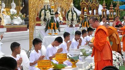 The rescued members of the Wild Boars football team receive their hair cut by a Thai Buddhist monk. EPA