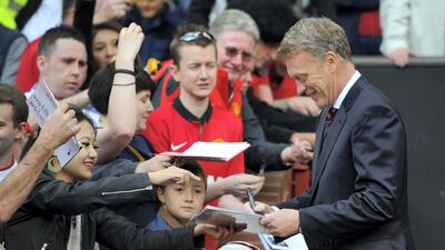 David Moyes signs autographs for United fans at Old Trafford ahead of their 2-0 Premier League win over Crystal Palace in September 2013. Getty