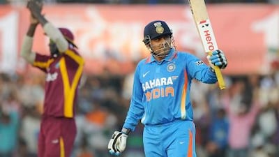 Sehwag raises his bat as he celebrates after scoring 150 runs during the fourth one-day international cricket match between India and West Indies at The Holkar Stadium in Indore. He finished in 219, a one-day record.