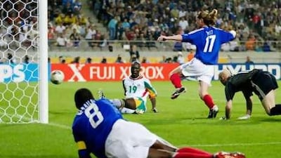 Papa Bouba Diop of Senegal scores the winning goal against France as goalkeeper Fabien Barthez, Emmanuel Petit and a grounded Marcel Desailly of France look on in the 2002 World Cup.