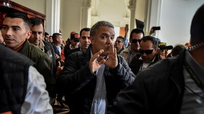 The presidential candidate for Colombia's Democratic Center Party, Ivan Duque (C), gestures amidst his supporters at the Church of Our Lady of Chiquinquira, on June 16, 2018, in Chiquinquira, department of Boyaca, Colombia, on the eve of Colombia's presidential run-off election. The runoff election in which Colombians will choose between leftist Gustavo Petro and rightist Ivan Duque will be held on June 17, 2018. Luis Robayo / AFP