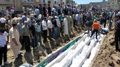 Mourners gather at a mass burial for victims reportedly killed by Syrian forces in Hula this week. UN observers have confirmed that artillery and tank shells were fired at a residential area and that at least 108 people, including many children, were killed.