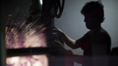 A projectionist at work in the projection room at Ariana Cinema.