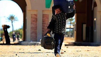 A migrant worker carries his belongings at the Libyan-Tunisian border crossing of Ras Jdir.